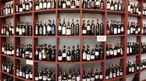 tipica parete di enoteca con scaffali pieni di bottiglie di vino