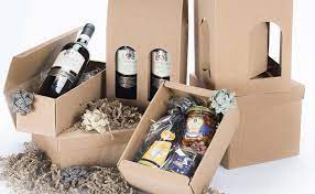 4 scatole confezionate a pacco regalo con dei vini paglia e fiori